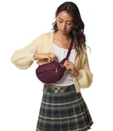 Riñonera Jansport modelo Fifth Avenue, color verde menta, con cierre principal y bolsillo frontal con cierre. Incluye parche con logo de la marca en el frente.