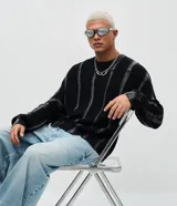 Suéter de punto con diseño texturizado y efecto acid wash, de corte boxy, cuello redondo y manga larga.