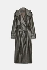 Trench coat de Zara con efecto piel texturizada en color gris oscuro. Presenta cuello con solapas, cierre frontal cruzado con botones, cinturón lazada del mismo material, mangas largas con trabillas y abertura en la espalda.