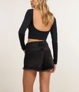 Short de jean femenino de corte slim, con trabillas en la cintura, bolsillos y cierre delantero tradicional. Presenta detalles desgastados y terminación deshilachada.