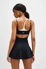 Vestido deportivo corto de color negro, con diseño fluido, tirantes finos y escote recto, ideal para tenis o actividades al aire libre.