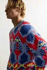 Jersey de punto tejido en hilatura de algodón, con diseño de patrones geométricos en colores celeste, azul, rojo y amarillo. Presenta cuello redondo, manga larga y acabados en rib.