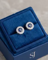 Aros abridores de plata en forma circular, con una piedra central azul rodeada de pequeñas circonias brillantes.