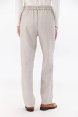 Pantalón de vestir gris oscuro, de corte recto y relajado, con cintura elastizada, cierre de cremallera y botón. Cuenta con bolsillos laterales.