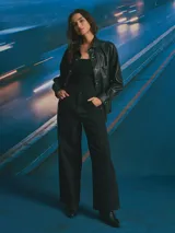 Sobrecamisa de cuero sintético en color negro, con cierre frontal de botones metálicos a presión, cuello clásico y un bolsillo frontal en el pecho.