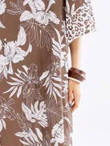 Vestido marrón con estampado floral blanco y detalles animal print en ruedo y mangas.