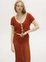 Top tejido calado color ladrillo, con cuello en V, mangas cortas y botones carey en el frente.