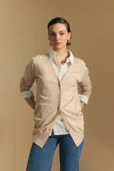 Cardigan largo de punto fino en color beige, con escote en V y cierre frontal con botones. Presenta un diseño de corte recto y mangas largas con puños acanalados.