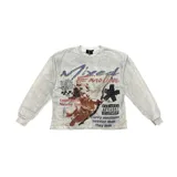 Remera de manga larga de color gris con efecto acid wash, corte holgado y diseño gráfico estampado en el frente con un ángel, texto y elementos de estilo grunge y streetwear.