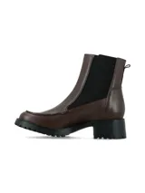 Bota tipo Chelsea de cuero color marrón, con paneles elásticos laterales en color negro, costura decorativa en la puntera y suela track dentada con taco cuadrado.