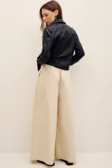Pantalón de corte holgado confeccionado en algodón, tiro alto, con bolsillos laterales y pinzas frontales.