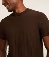 Remera de manga corta color beige, con cuello redondo y tejido texturizado acanalado.