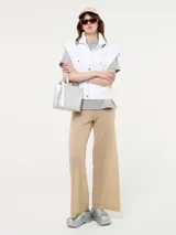 Chaleco blanco de jean con botones metálicos y sisas desflecadas.