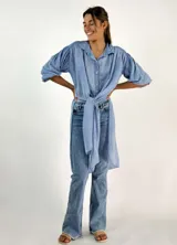 Camisa celeste de algodón con mangas abullonadas y lazo para atar en la cintura.