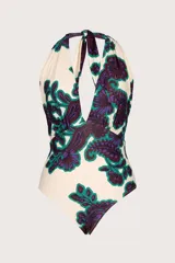 Traje de baño entero con estampado floral en tonos morado y verde sobre fondo blanco. Diseño con escote en V pronunciado y tirantes que se atan al cuello.