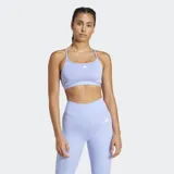 Top deportivo Adidas de soporte ligero, color lila claro, con tiras delgadas en la espalda y logo pequeño en el frente.