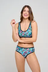 Bombacha de bikini tipo culotte tiro alto, con laterales anchos y ribete en color negro. Presenta un diseño estampado floral en tonos rosados, naranjas y azules.