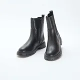 Botines negros de caña media, con elástico en los laterales y suela track.