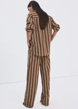 Pantalón tiro medio de corte recto con diseño estampado a rayas, detalle de pinzas, bolsillos laterales y cierre oculto con ganchos y cremallera.