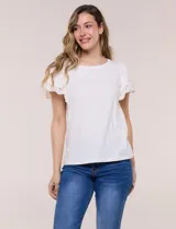 Remera blanca semi entallada de algodón con elastano, escote redondo y mangas cortas estilo tulipán confeccionadas en broderie calado con bordados florales y terminación festonada.