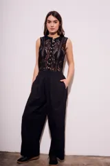 Pantalón negro de corte amplio, con cintura elástica y textura arrugada.