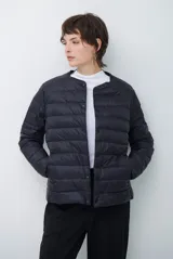 Campera acolchada tipo puffer, color negro, con cuello redondo, cierre frontal mediante botones a presión y bolsillos laterales.