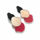 Aros colgantes con piezas geométricas irregulares en color negro, dorado y rojo.