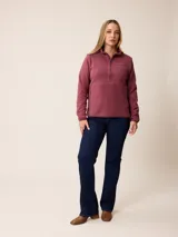 Canguro de sherpa color bordó, con cuello alto y cierre frontal parcial. Presenta un bolsillo con cierre en el pecho y bolsillos laterales, confeccionado en tejido de textura suave y abrigada.