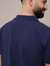 Chomba azul marino de piqué de algodón con cuello clásico y tapeta de dos botones. Logo bordado en el pecho. Corte clásico.