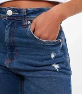 Pantalón mom jeans de tiro alto, color celeste claro, con bolsillos delanteros y traseros, cierre con botón y cremallera, y ruedo doblado.