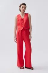 Chaleco rojo de lino con botones de carey en el frente y calce recto.