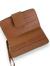 Billetera tipo sobre confeccionada en cuero vacuno color verde con textura tipo cocodrilo. Tiene cierre perimetral con cremallera, correa de mano desmontable y broche de cuero marrón con logo de la marca.