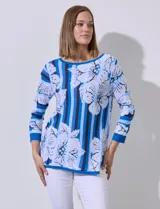 Buzo tejido en hilado fino, con cuello redondo y mangas 3/4. Presenta un estampado floral en tonos azules sobre un fondo a rayas verticales en diferentes tonos de azul.