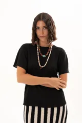 Blusa de textura arrugada en color negro, con cuello redondo y mangas cortas de corte holgado.