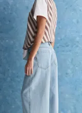 Jean negro de tiro alto y pierna recta amplia, con bolsillos funcionales y terminaciones clásicas de denim.