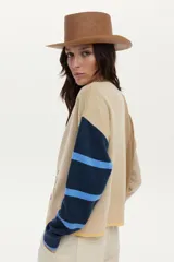 Cardigan de punto con ilustraciones en jacquard y detalle bordado en el frente, mangas largas con puños acanalados, escote redondo y cierre frontal de botones.