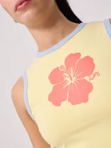 Musculosa crop amarilla con estampado de flor roja en el frente y ribetes grises en cuello y sisas, de la marca Rusty.