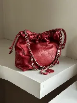 Cartera tipo bolso capitoneada de cuero color negro, con asa de cadena plateada y cuero entrelazado. Forrada por dentro y con bolsillo interno.