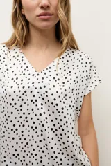 Blusa de manga corta color crudo con estampado de lunares negros y escote en V.