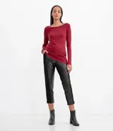 Suéter de punto color rosado, con cuello barco, mangas largas y puños con botones decorativos. El dobladillo también es acanalado.