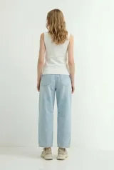 Pantalón jean de corte balloon, color celeste claro, tiro medio y diseño amplio en las piernas con costuras en las rodillas.