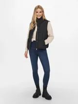 Chaleco puffer acolchado con cuello alto y cierre frontal de cremallera metálica. Confeccionado en poliéster reciclado.