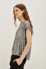 Remera azul marino con lentejuelas verticales, cuello redondo y mangas cortas.