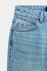 Jeans de tiro alto con diseño de cinco bolsillos, pernera recta y corte largo. Presenta cierre frontal con cremallera y botón metálico.