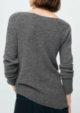 Jersey de punto medio color gris, con diseño recto, cuello barco, manga larga y bajo asimétrico. Cuenta con detalle metálico en el hombro.