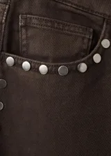 Jeans de corte recto y tiro medio color marrón, con detalles de tachas metálicas en las costuras laterales.