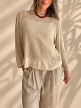 Sweater de punto calado color rosado, con diseño holgado, cuello redondo y mangas largas, que incluye una musculosa interior con terminación bordada en el bajo.