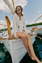 Chaqueta de punto blanco con diseño pointelle, cuello redondo, manga larga y cierre frontal con botones.