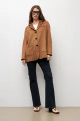 Blazer símil gamuza color camel, de corte recto y holgado, con solapas clásicas, cierre frontal de tres botones y bolsillos aplicados al frente.