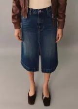 Falda midi de jean azul con abertura frontal y ruedo desflecado.